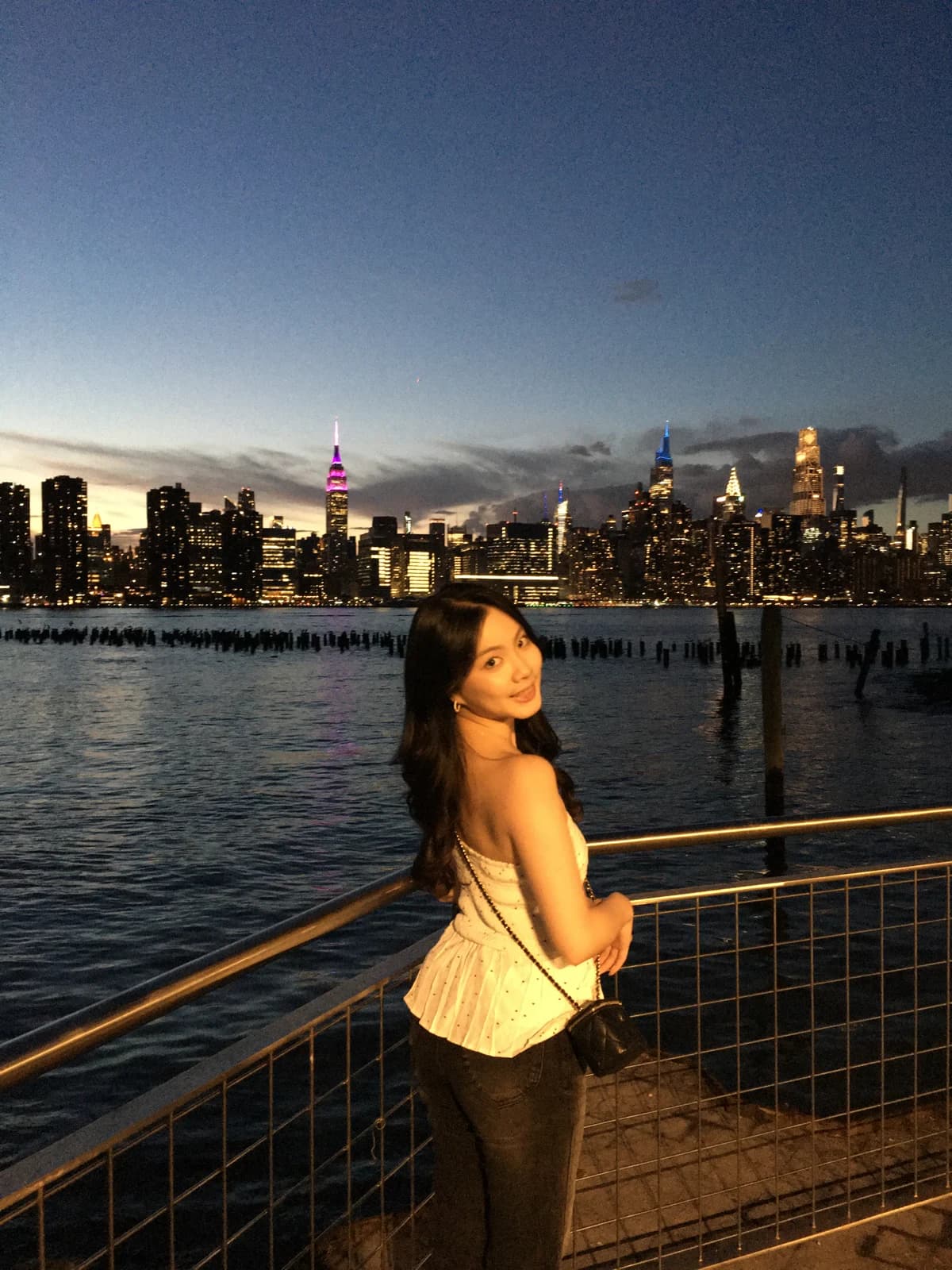 Melody by the waterfront with the illuminated skyline at dusk