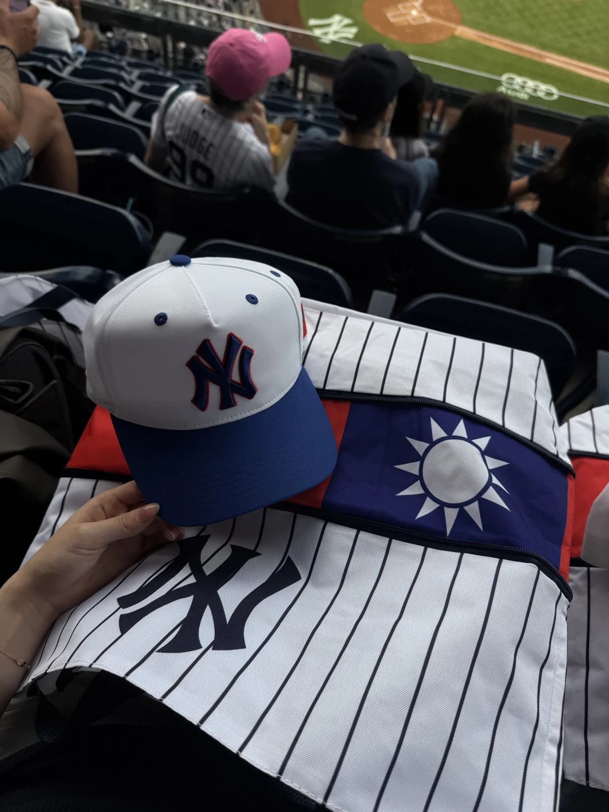 A Yankees cap and jersey with a Taiwan flag at a baseball game